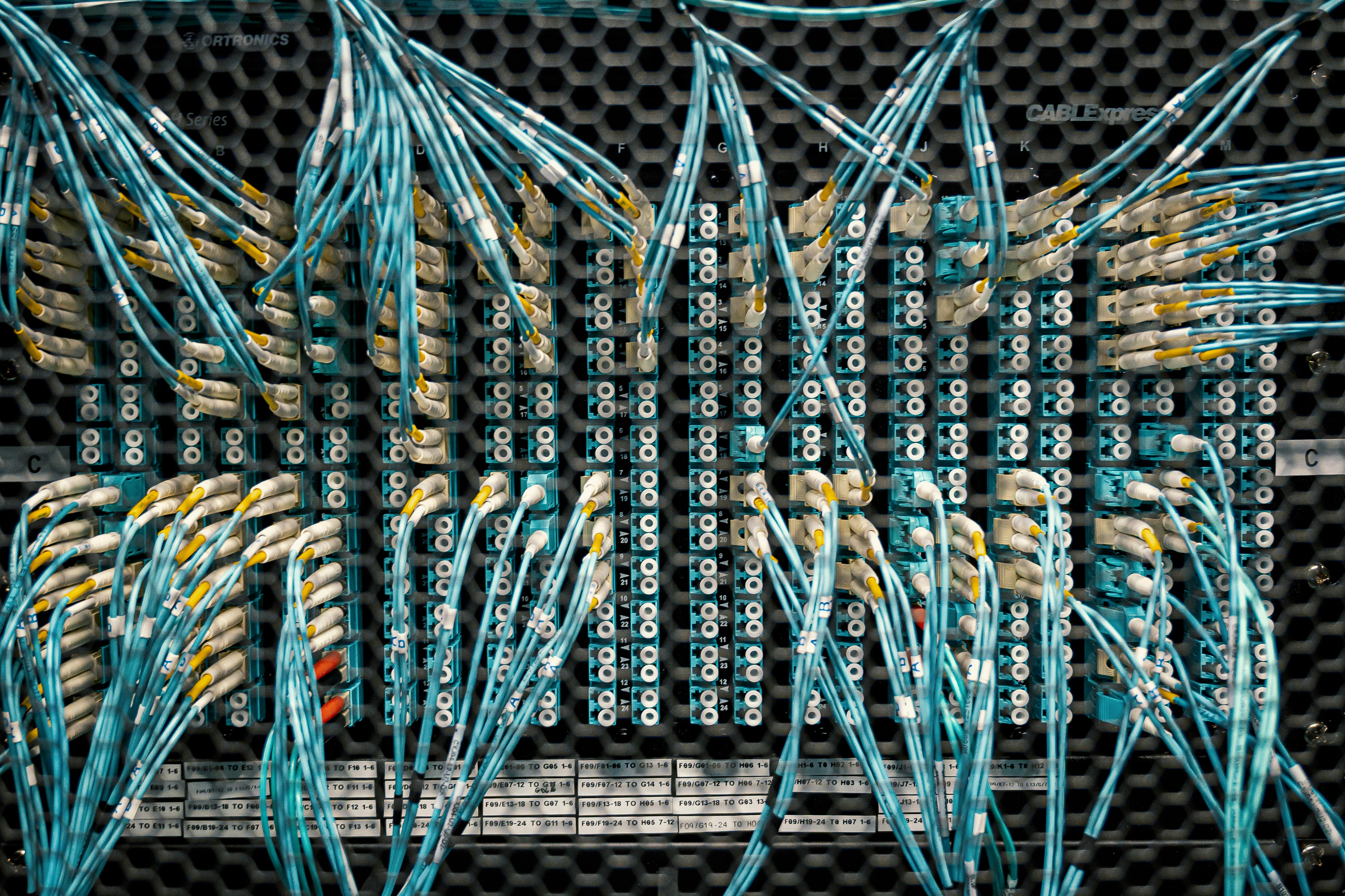 Close-up of fiber optic cable management system in a data center, showcasing high-density structured cabling for energy infrastructure.