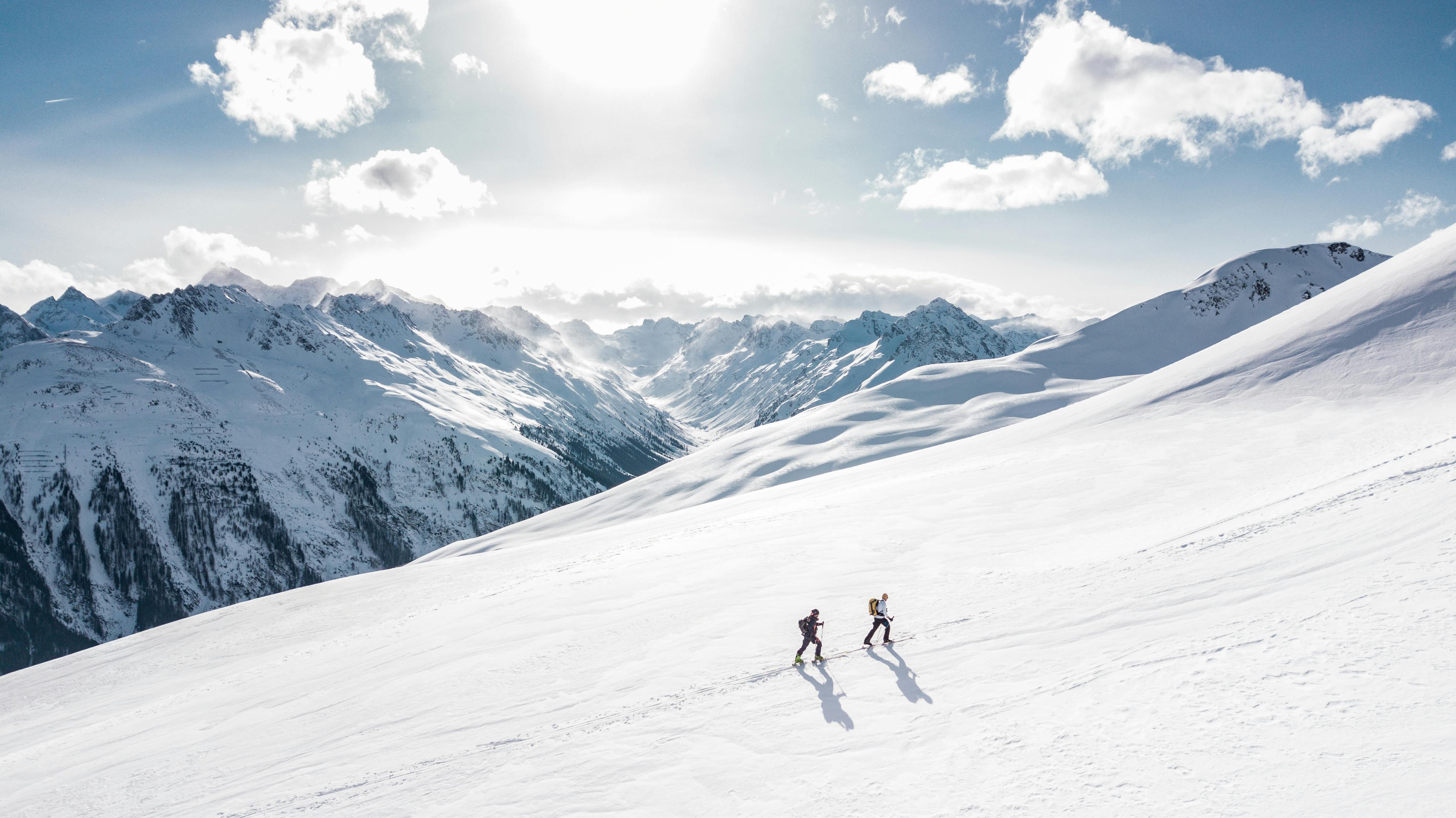 Two explorers traversing a remote alpine snowfield in high-altitude conditions—ideal terrain for Gletscher Energy’s cold-resistant portable powerbanks and rugged power stations designed for extreme off-grid environments.