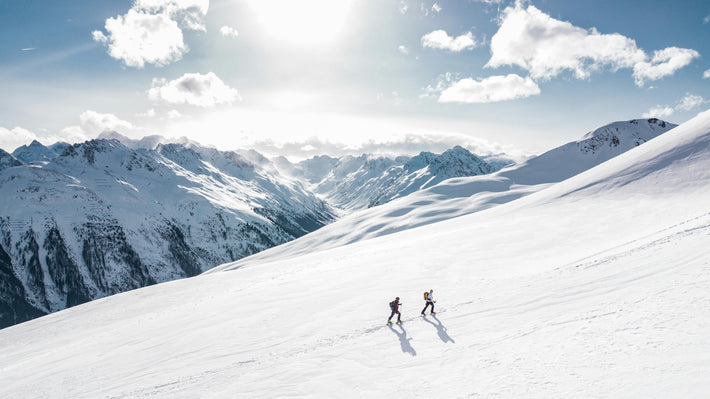 Two explorers traversing a remote alpine snowfield in high-altitude conditions—ideal terrain for Gletscher Energy’s cold-resistant portable powerbanks and rugged power stations designed for extreme off-grid environments.